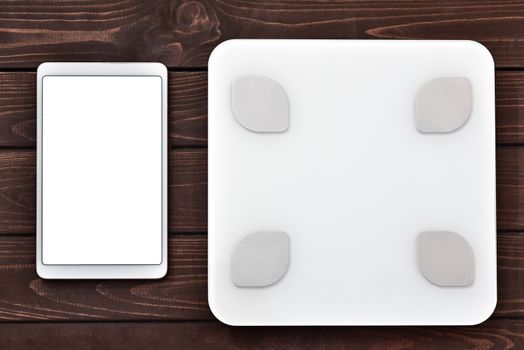 Glycemic index Fitness and weight loss concept, white scale and tablet on wooden table, top view,