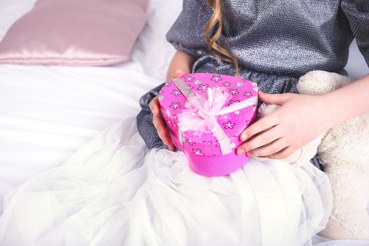 Young smiling woman holding red gift box like a heart