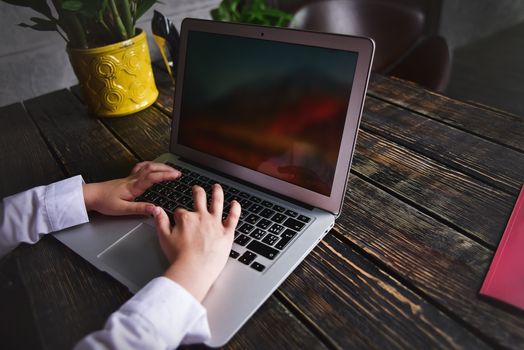 Person working on a modern laptop on a wooden bench