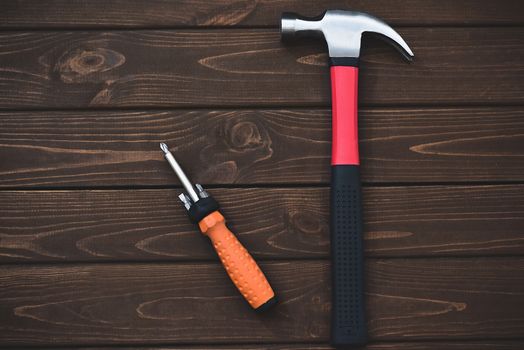 close-up tools as hammer and screwdriver on a wooden background. work concept.