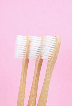 Bamboo toothbrushes on pink background. Zero waste concept.