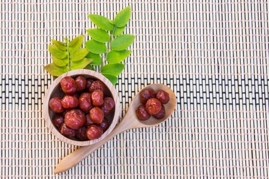 Gooseberry in syrup put in wood bowl and spoon on bamboo wicker, Mayom chueam 