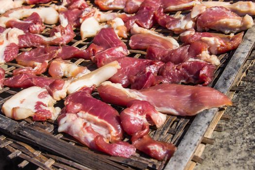 Preserving pork meat by dry with Sun-dried on bamboo basket weave palat.