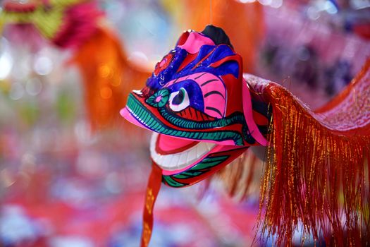 Bright colorful Dragon and Lion puppet paper toys being sold during a cultural chinese festival in Northern Thailand, Southeast Asia