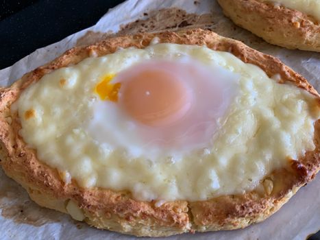 Home made diet proper nutrition khachapuri - traditional Georgian pie with cheese and egg. Horizontal stock image.