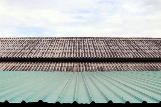 roof wavy tile and zinc, roofing tile old and zinc roof green, white or grey roofing tile old on sky background