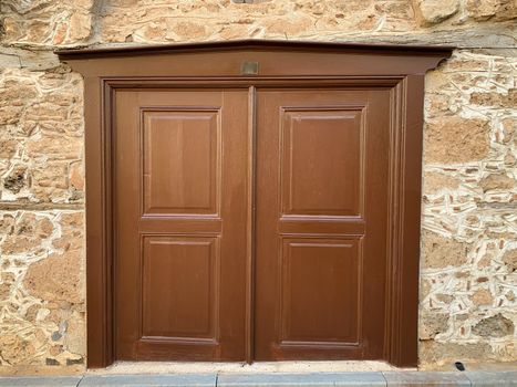 An old historical stone wall with a wooden door in Antalya Old town Kaleici, Turkey. Ottoman time architecture. Horizontal stock photo.