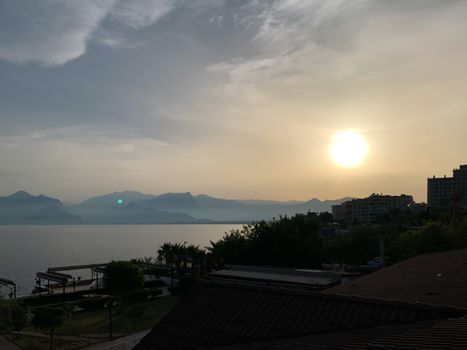 Beautiful summer sunset sunrise over Mediterranean sea with mountains silhouettes. Horizontal stock image.