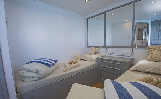 Twin beds in cabin of a luxury private motor yacht