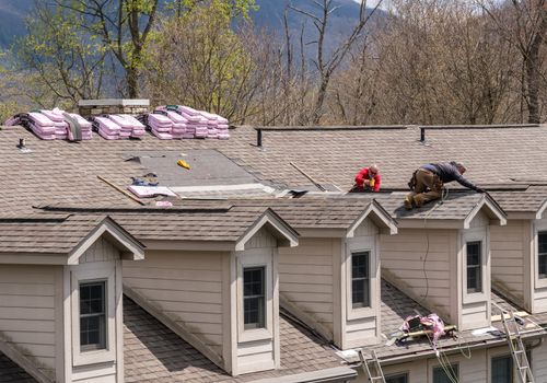 Morgantown, WV - 18 April 2020: Roofing contractors replacing the old shingles on a townhouse roof