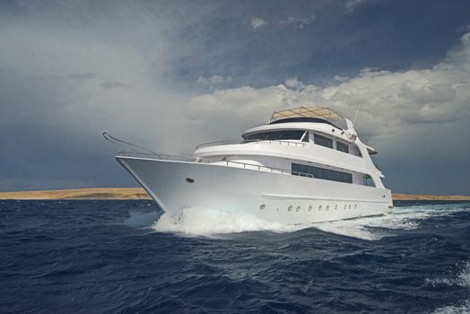Large luxury motor yacht under way sailing out on tropical sea ocean with cloudy sky background