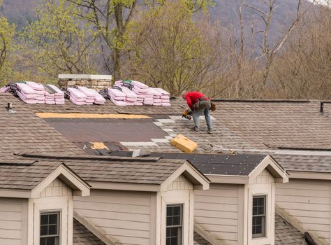 Morgantown, WV - 18 April 2020: Roofing contractors replacing the old shingles on a townhouse roof