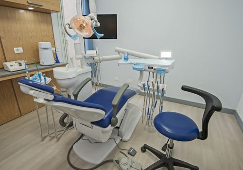 Interior design of dentist surgery room in medical clinic with chair and equipment