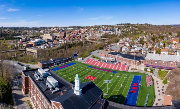 Morgantown, WV - 6 April 2020: Aerial drone view of the downtown area of Morgantown West Virginia with high school football field in the foreground