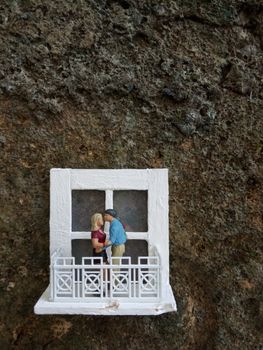 Conceptual Illustration photo, Young Couple Mini figure Toy kissing at White Balcony