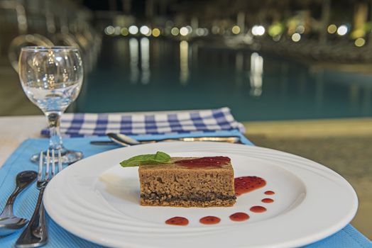 Chocolate sponge cake dessert food at luxury a la carte restaurant by swimming pool with sauce