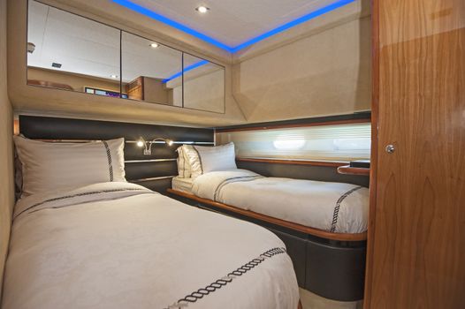 Twin beds in cabin of a luxury private motor yacht