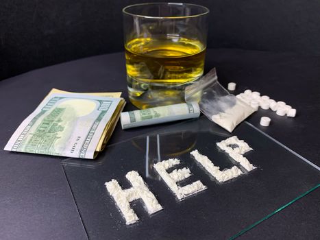 Pills; us dollar banknotes; whiskey and cocaine; on a gray background. Stop drugs concept. A word "help" written with cocaine. Stock image.