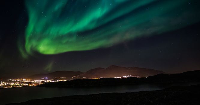 Massive green Northern lights shining over Nuuk city, Greenland