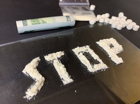 Pills, us dollar banknotes and cocaine  on a gray background. Stop drugs concept. Stock image.