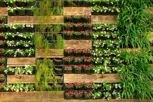 Bright flower floral decorative wall fence, vertical flowerbed plant pot. Stock image.	