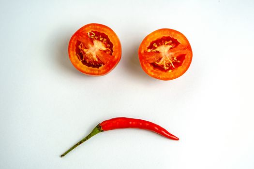 Red tomatoes and red peppers are sad in the white background