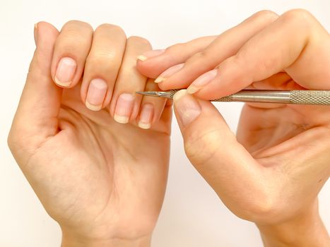 Female woman doing manicure at home on a white background. Self manicure close up