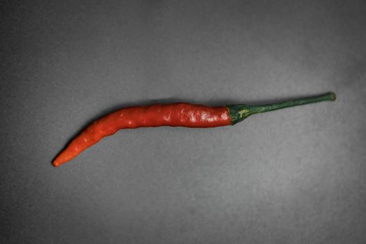 A close up of a red chilli in a black background