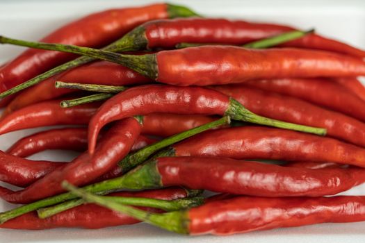 Close-up shot of red peppers on a white background. Fresh food ingredients concept.