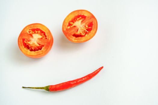 Tomatoes and red peppers smiling in a good mood white background