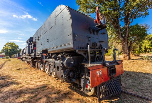 Old retro steel locomotive train standing on the rails in Livingstone, Zambia