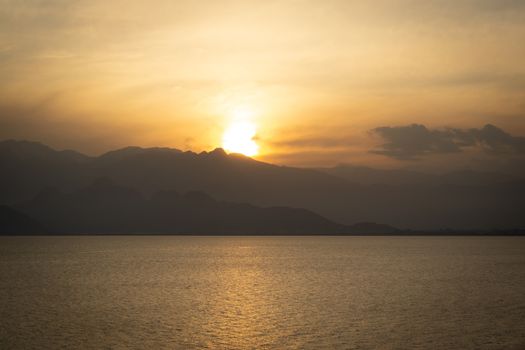 Majestic Tropical Orange Summer Sunset Sunrise Over Sea with Mountains Silhouettes