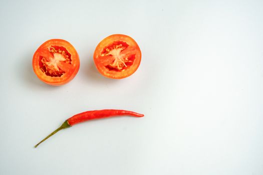 Red tomatoes and red peppers are sad in the white background