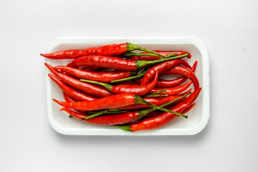 Close-up shot of red peppers on a white background. Fresh food ingredients concept.