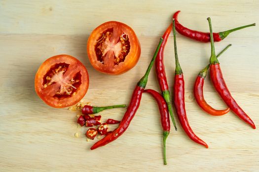 Close-up shot of chili and red tomatoes on a wooden cutting board background. Fresh food ingredients concept.