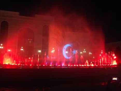 Projection of Turkish flag on a water fountain at night. Stock image of a spectacular water and multicolored light and laser show.