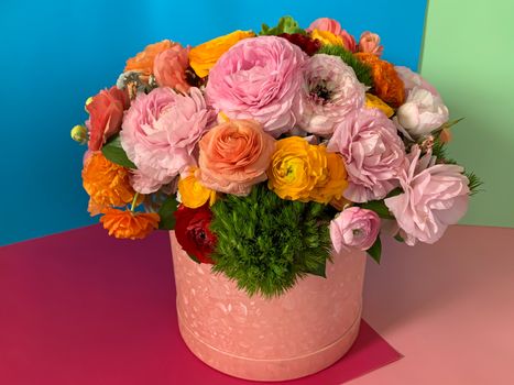 Bright colorful pink yellow orange persian asian buttercup ranunculus asiaticus bouquet fresh flowers in round box