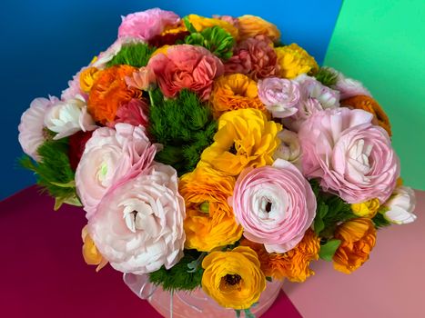 Bright colorful pink yellow orange persian asian buttercup ranunculus asiaticus bouquet fresh flowers in round box