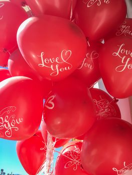 Close up of a bunch red heart shaped balloons with "i love you" text on them. Valentine's day concept vertical stock image.