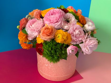 Bright colorful pink yellow orange persian asian buttercup ranunculus asiaticus bouquet fresh flowers in round box