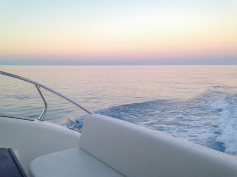 Beautiful sunset sky and sea view from a white yacht. Horizontal stock image.