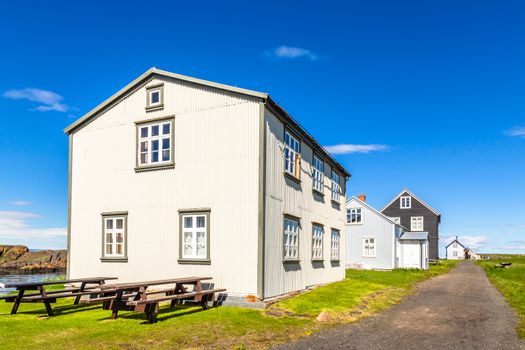 Fishing village street with living wooden houses  with blue sky in the background, Flatey island, Iceland