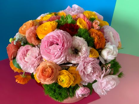 Close up bright colorful pink yellow orange persian asian buttercup ranunculus asiaticus bouquet fresh flowers in round box