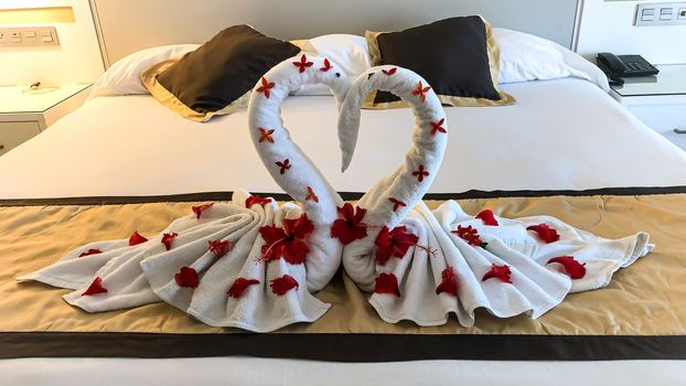 Two nice towel swans on a hotel's bed