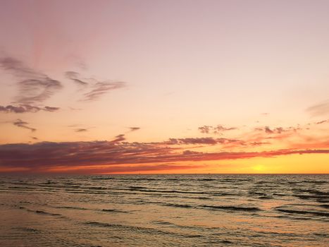 Beautiful colorful sunset at calm Baltic sea. Vertical image
