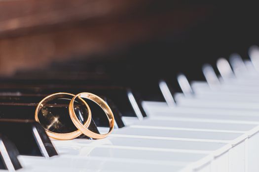 gold wedding rings on a piano key