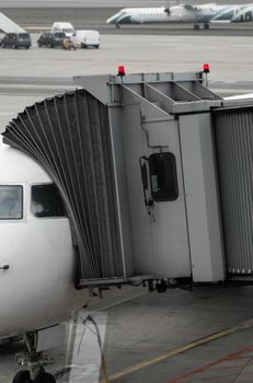 Plane on airport connected to gate sleeve. Aircraft and sleeve. Gate at the airport for passengers to plane boarding