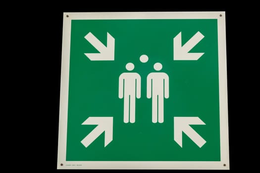 Krausnick, Brandenburg/Germany - 11.01.2020: A green rectangular sign for a collection point in case of an emergency in case of fire or disaster, placed in the height with white pictograms for persons and arrows.