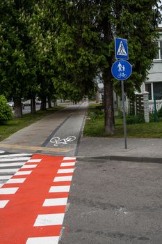 Cycling path with a symbol of bike on a ground through avtomobile road. Bike path in a modern city