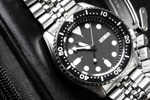 Close up men dive watch with stainless steel bracelet, luxury wristwatch for men.